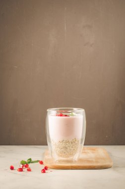 Yoğurt. Garnet ve nane cam bir ahşap tepsi ve beyaz bir tablo üzerinde dağınık nar taneleri ile yoğurt. Koyu arka plan kopya alanı ile. Seçici odak. Şekerli tatlı