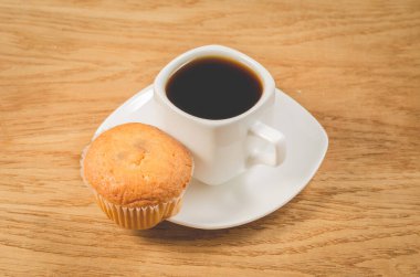 Kahve molası. Beyaz fincan espresso ve tahtanın üzerinde kek. Kahvaltı konsepti.