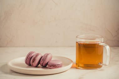 tatlı macaroons veya macaron ve beyaz bir arka planda, Fransız tatlı bir bardak çay 
