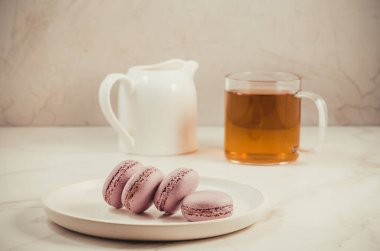 tatlı macaroons veya macaron ve beyaz bir arka planda, Fransız tatlı bir bardak çay 
