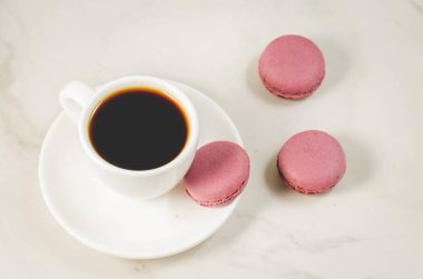tatlı macaroons veya macaron ve kahve fincan beyaz bir arka planda üstten görünüm. Fransız tatlı