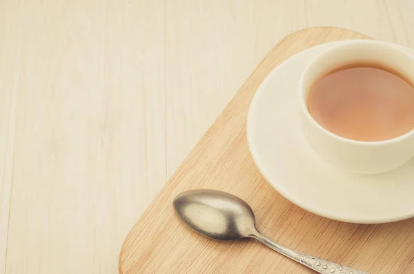 white cup of tea and spoon on a wooden tray/white cup of tea and spoon on a wooden tray. Top view. Copy space