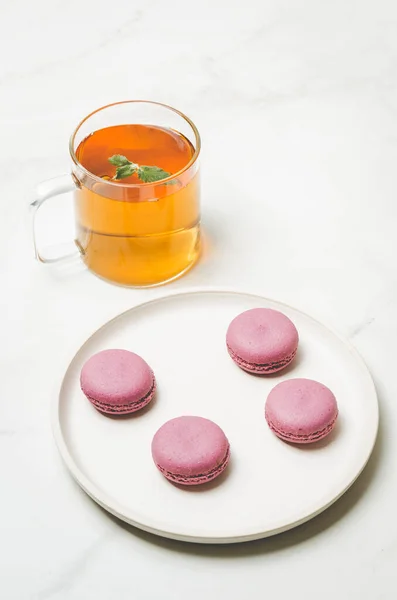그릇에 단맛있는 마카롱이나 배경에 유리잔에 박하사탕을 프랑스식 디저트 — 스톡 사진