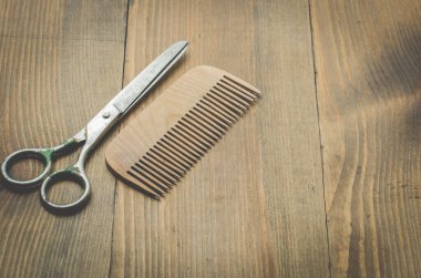 Eski tahta arkaplanda makas ve tarak, üst görünüm ve boşluk kopyala