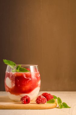 Bir bardak ahududulu yoğurt ile naneli / sağlıklı kahvaltı - ahududulu yoğurt ve ahşap tepside nane. Seçici odak