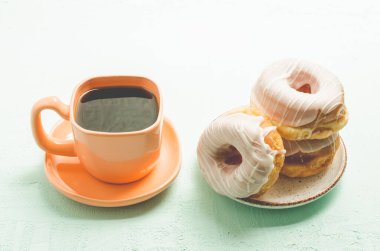 Kahve molası. Sütsüz kahve ve çikolata jöleli bir donat. Ahşap arkaplan.