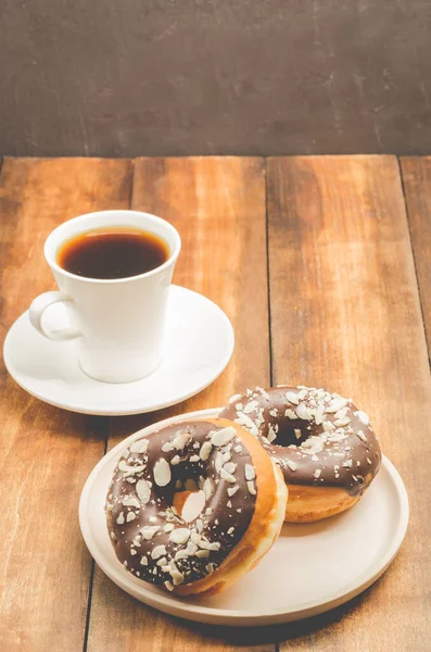 喝咖啡休息 白杯与黑咖啡和甜甜圈在巧克力釉中 木制背景 — 图库照片