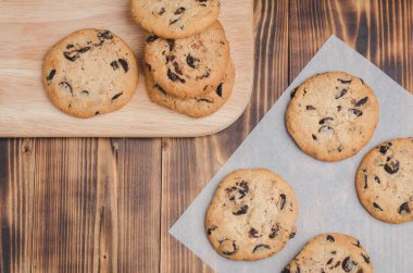 Tahta bir masada çikolatalı kurabiyeler. Taze hamur işleri / Çikolatalı kurabiyeler ahşap bir masada. Taze pastalar. Üst görünüm ve boşluk kopyala.