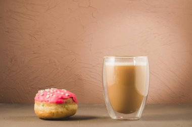Kırmızı jöleli çörek ve kırmızı jöleli kapuçino / çörek ve kahverengi arka planda kapuçino bardağı..