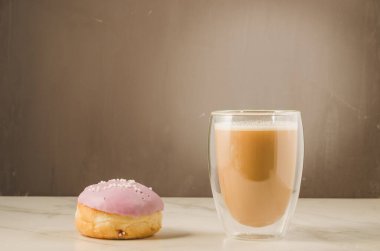 Menekşe jöleli çörek, kapuçino bardağı, mor jöleli çörek ve kapuçino bardağı. Seçici odak