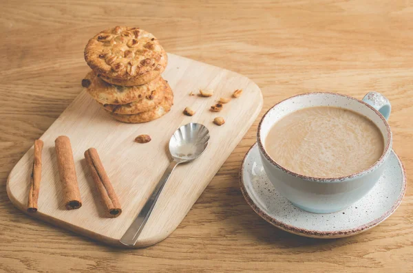 cinnamon sticks, cookies and a cup of coffee/cinnamon sticks, cookies and a cup of coffee on a wooden background