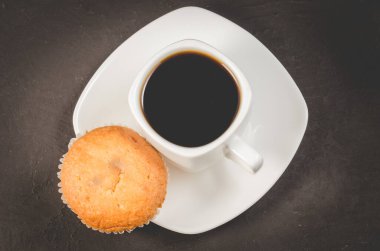 Kahve molası. Beyaz fincan, sade kahve ve kek, üst manzara. Kahvaltı konsepti