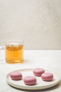 tatlı macaroons veya macaron ve beyaz bir arka planda, Fransız tatlı bir bardak çay 