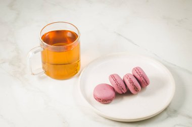 tatlı macaroons veya macaron ve beyaz bir arka planda, Fransız tatlı bir bardak çay 
