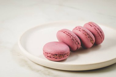 Beyaz bir masada beyaz bir kasede tatlı badem kurabiyesi ya da makaron. Fransız tatlısı 