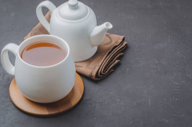 - Çay. Bir fincan çay ve çaydanlık. Siyah taş bir masada beyaz eşya. Boşluğu kopyala