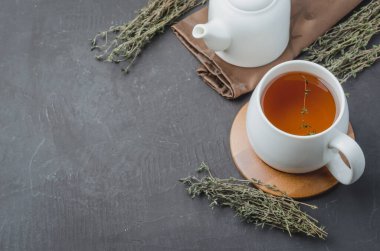 Kekikli bitki çayı, beyaz bardaktan çay ve çaydanlık manzaralı. Kopyalama alanı