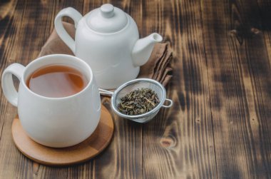 - Çay. Beyaz çay, kuru çay ve çaydanlık ahşap masada. Kopyalama alanı