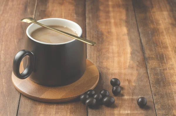 Mug Hitam Cappuccino Dengan Sendok Dalam Dukungan Kayu Dengan Tetes — Stok Foto