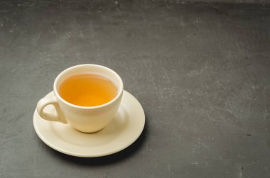 Koyu taş masada çay fincanı. Metnin için kopyalama alanı