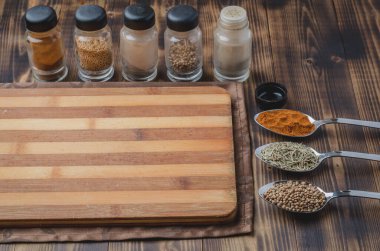 Çeşitli baharatlar, ahşap masa arkaplanı üzerine tahta kesme.. 