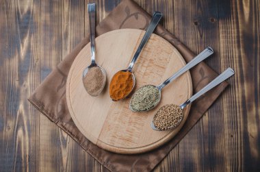 Tahta yuvarlak destekli kaşıklardaki çeşitli aromatik baharatlar seti. Üst görünüm