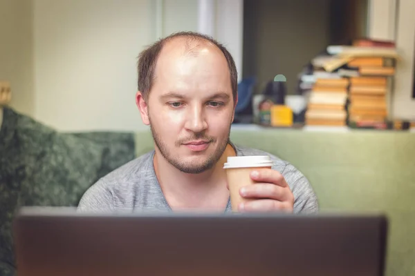 young man with having coffee while using his laptop/young man with having coffee while using his laptop at home