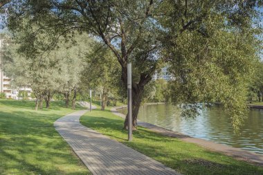 Şehir parkında yürüyüş için nehir boyunca. Yazın güzel manzarası. Açık hava yürüyüşü