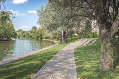 Nehir kenarındaki parkta yürüyüş yolu. Yazın güzel manzarası.