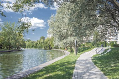 Nehir kenarındaki parkta yürüyüş yolu. Yazın güzel manzarası.