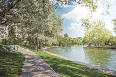 Nehir kenarındaki parkta yürüyüş yolu. Yazın güzel manzarası.
