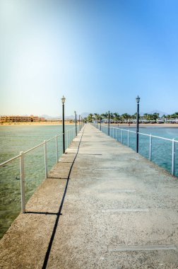 Güneşli bir günde denize açılan iskele. Güneşli bir günde denize bakan boş iskele.