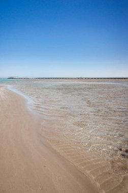 Mavi gökyüzü olan güzel deniz manzarası. Deniz ve güneşli gökyüzü üzerindeki boş yaz plajı.