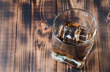 Ahşap bir masada buz küplü bir bardak konyak. Ahşap bir masada buz küplü bir bardak konyak. Üst görünüm, kopyalama alanı