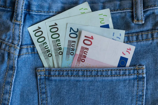 Euro banknotes in blue jeans pocket closeup. Back jeans pocket full of euro banknotes. Euro money