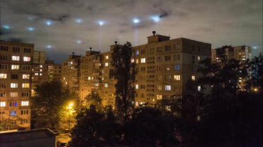 4K Zaman atlaması, arka planda bir sürü spot ışığı çalışan bulutlar ve akşam kenar mahallelerde.