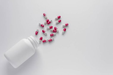 Çeşitli ilaç hapları, haplar, kapsüller ve beyaz arka planda bir şişe. Metin için alanı kopyala