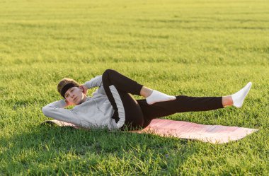 Genç adam yeşil alanda basın egzersizleri yapıyor.