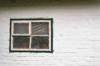 Beyaz tuğla duvardaki eski pencere