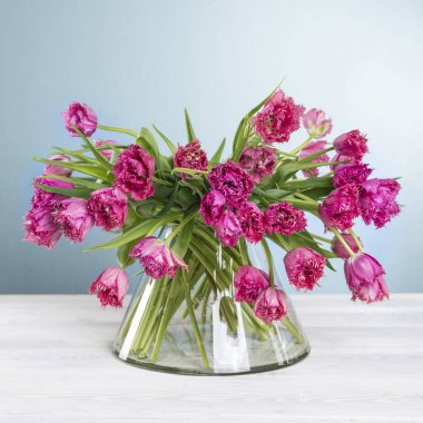 Lale buketi Vazoda beyaz ahşap masa üzerinde