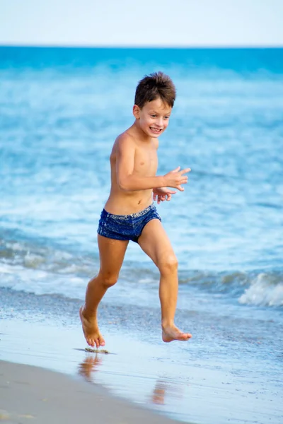 Sex år gammal pojke som leker på stranden — Stockfoto