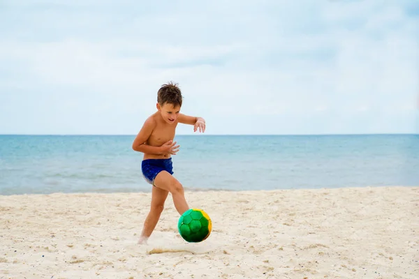 Junge spielt Fußball am Strand — Stockfoto
