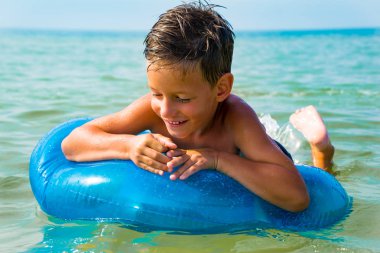 Küçük çocuk deniz kauçuk halka ile Yüzme