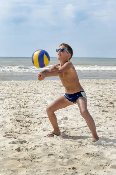 Niño jugar voleibol en una playa de mar — Foto de Stock