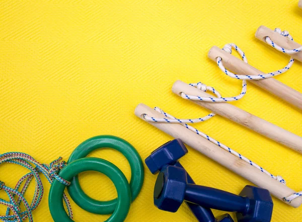 Hög vinkel syn på hantlar, repstege, Gymnastringar och gula fitness matta. — Stockfoto