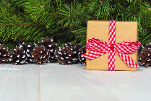 Christmas gift box. Christmas present in gift box at white wooden table. Copy space.