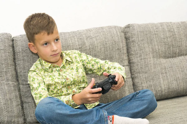 Jongen spelen van videospellen met joystic zittend op de Bank — Stockfoto