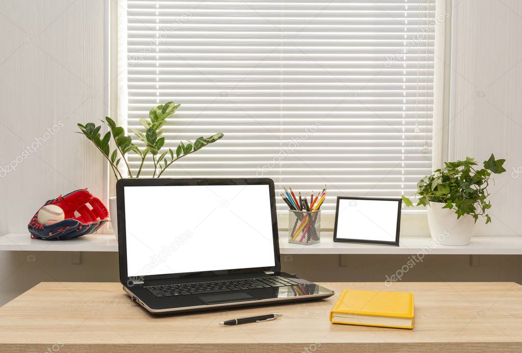 Modern workplace with mock up laptop computer on table, business desk space with files, books, pen, photo frame houseplant and supplies.