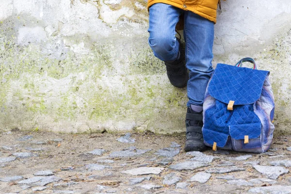Παιδί αγόρι πόδια και σακίδιο ενάντια στον τοίχο — Φωτογραφία Αρχείου