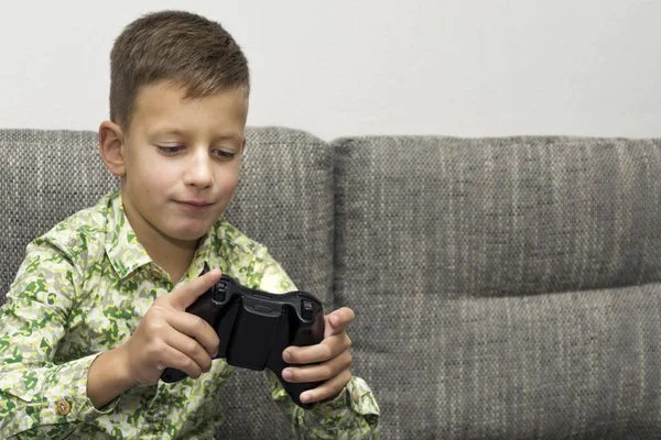 Jongen spelen van videospellen met joystic zittend op de Bank — Stockfoto